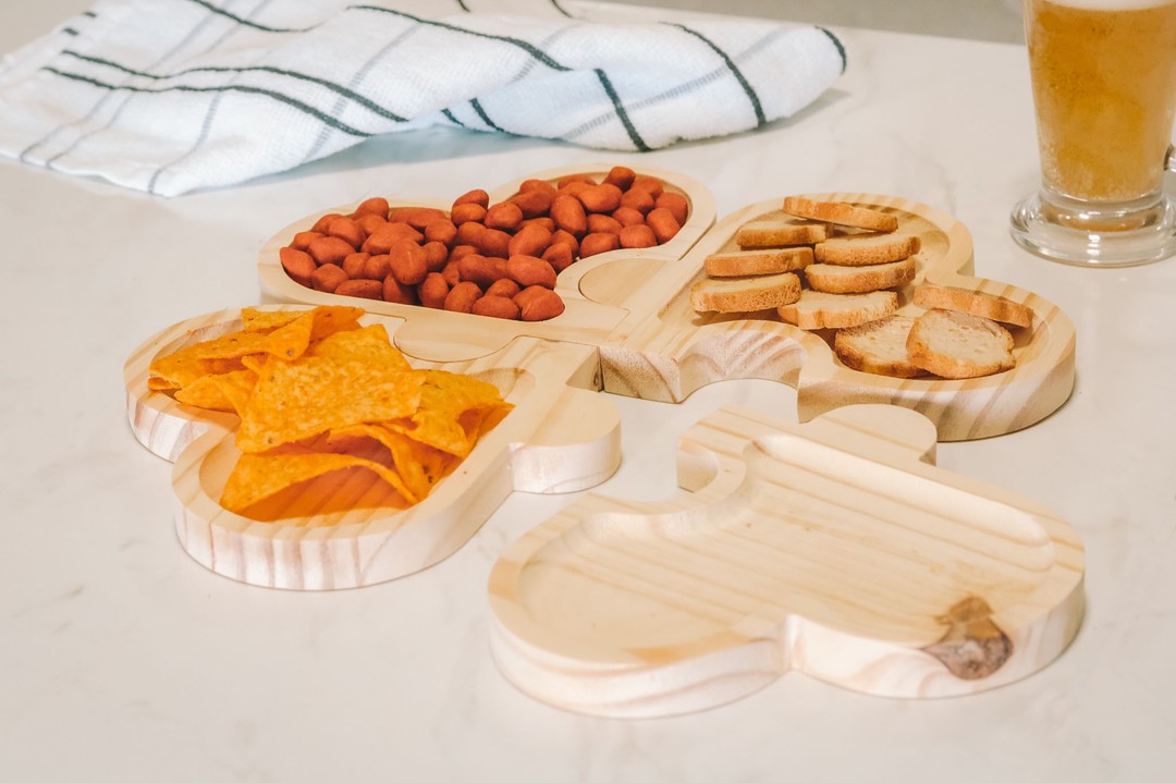 Petisqueiras de madeira em formatos decorativos servindo aperitivos